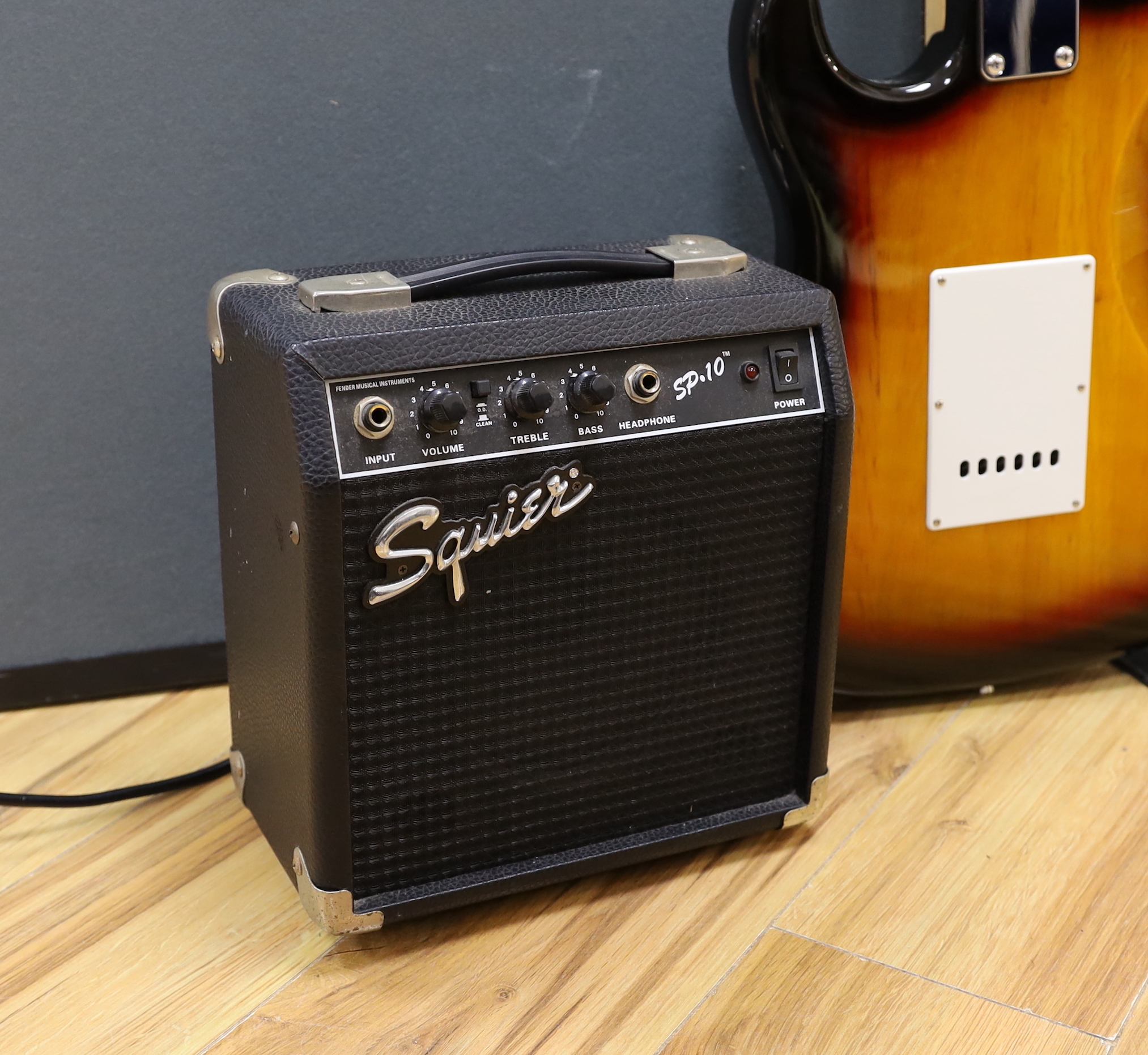 A Squier Strat by Fender Sunburst electric guitar made in China with rosewood neck, together with a small Squire SP-10 amp
